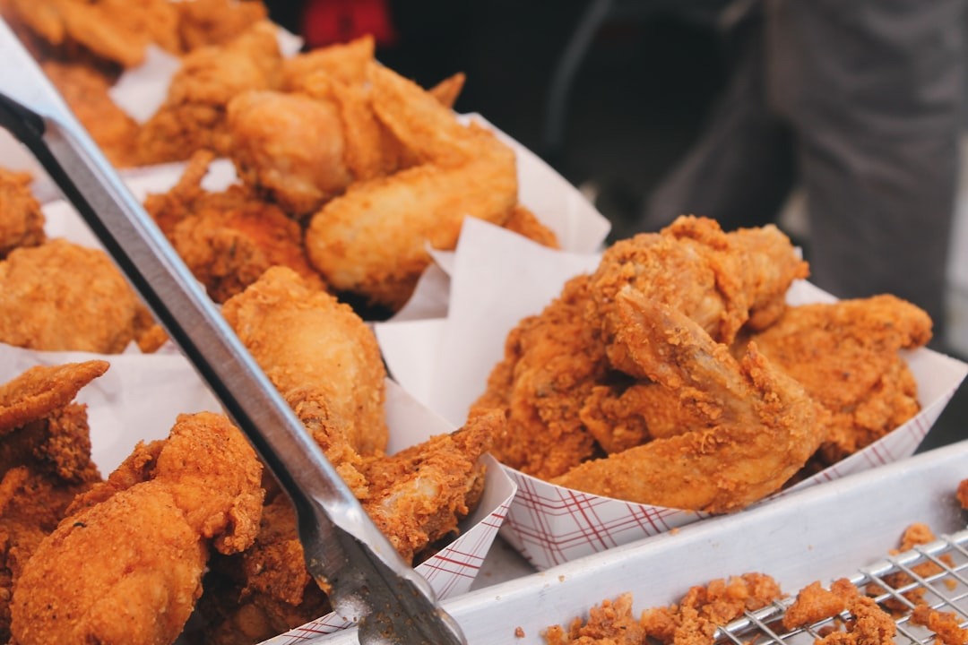 Golden fried chicken wings and pieces piled in trays.